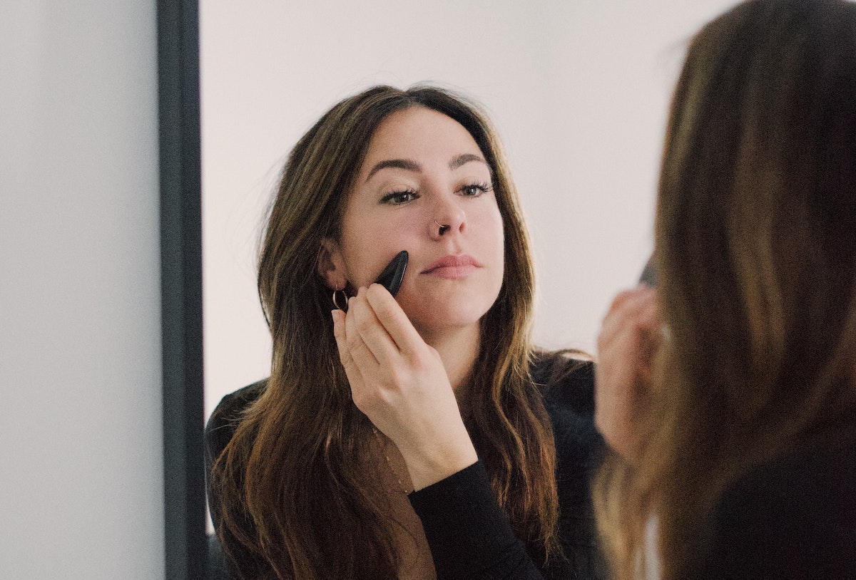 Woman doing gua sha on face