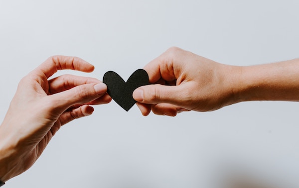 Two hands holding a cardboard heart